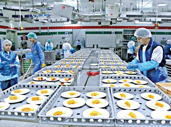 Catering staff assembling airline meal trays